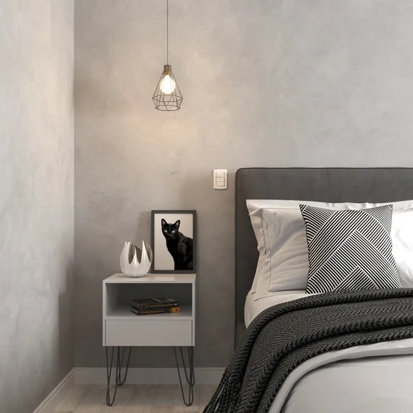 Quarto com paredes de cimento queimado, cama de casal e mesa de cabeceira cinza.
