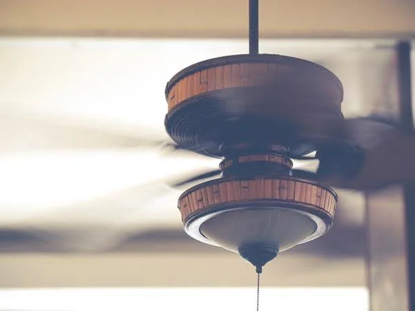 Ventilador de teto com tonalidade amadeirada em funcionamento.