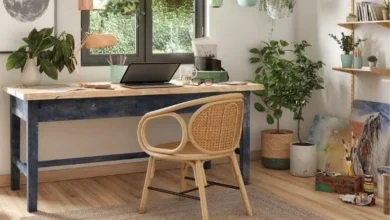 Escritório com tapete de fibra natural e móveis de madeira, além de vasos de plantas espalhados.