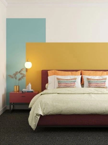 Pintura para quarto com parede branca e forma retangular amarela e outra azul, com cama vermelha.