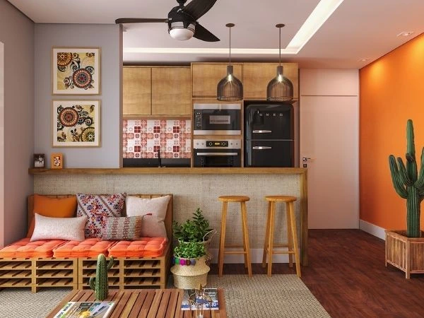 Sala com sofá de pallets, bancada com bancos de madeira e parede lateral laranja.