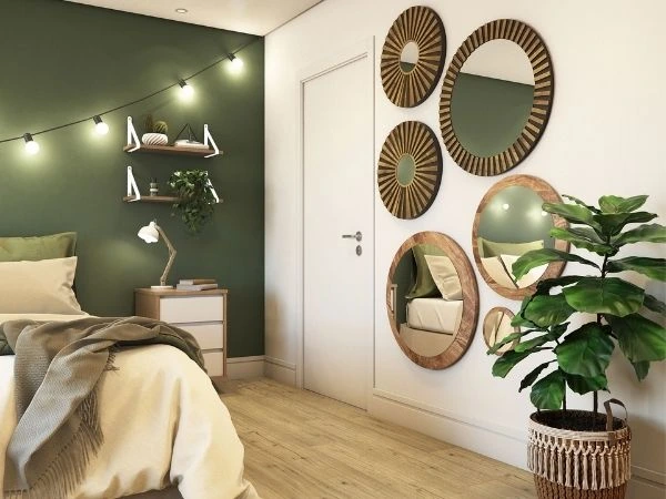 Quarto branco com parede verde e cama posta, com espelhos decorativos na parede.