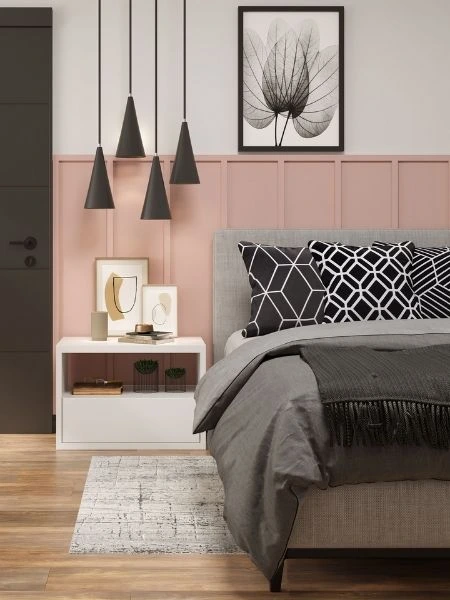 Quarto com meia parede rosa e branco com cama posta cinza.