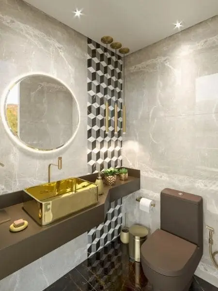 Banheiro com paredes marmorizadas cinza e piso preto. Papel de parede preto e branco e pia dourada.