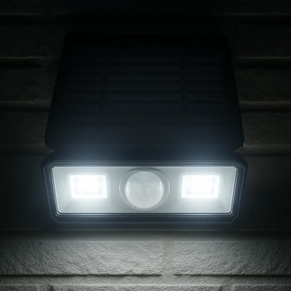 Parede externa preta sendo iluminada por uma arandela solar também preta.