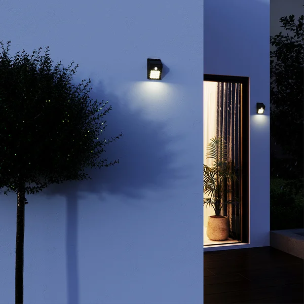 Parede externa iluminada por arandelas solares pretas.