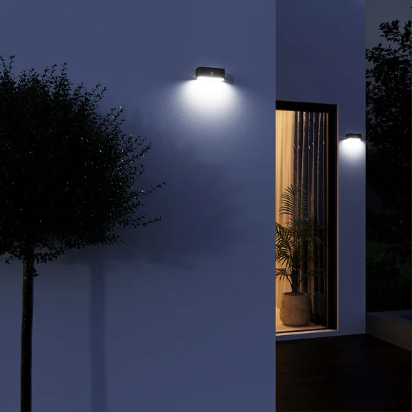 Parede externa iluminada por arandelas solares pretas retangulares da Inspire.