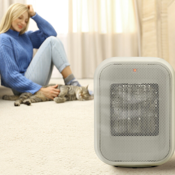 Qual aquecedor gasta menos energia: Aquecedor de Ar 3 em 1 Portátil e mulher ao fundo