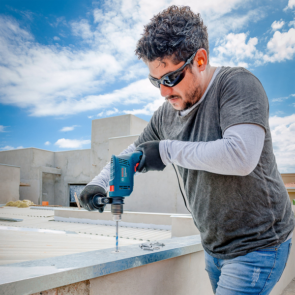 Parafusadeira e furadeira profissional: Furadeira de Impacto Bosch GSB 550 sendo utilizador em obra