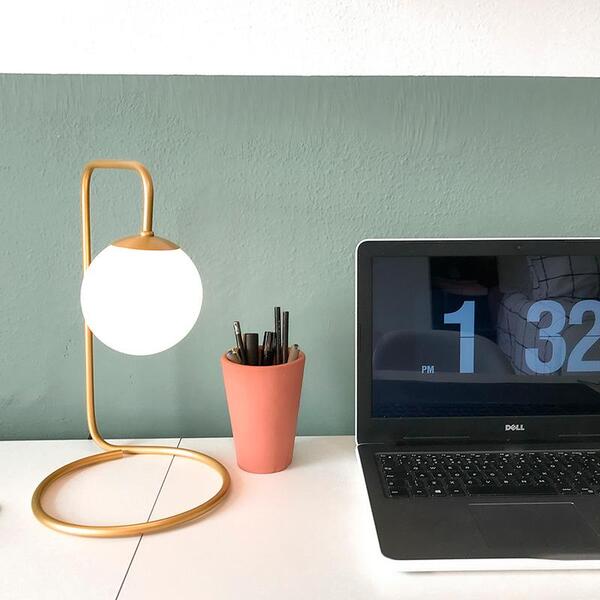 Lustre e Luminária: Luminária de Mesa Dourada ao lado de notebook