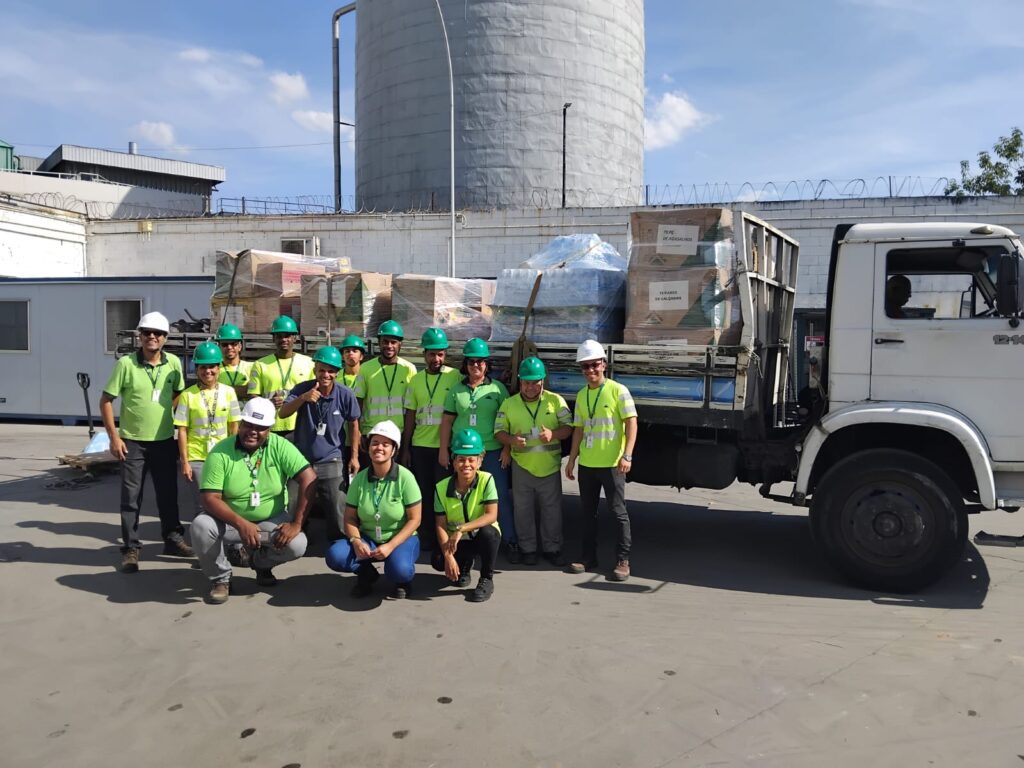 Colaboradores da Leroy Merlin em frente ao caminhão cheio de caixas de arrecadação para o Rio Grande do Sul.