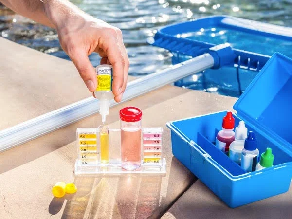 Pessoa fazendo teste de ph na água de uma piscina.