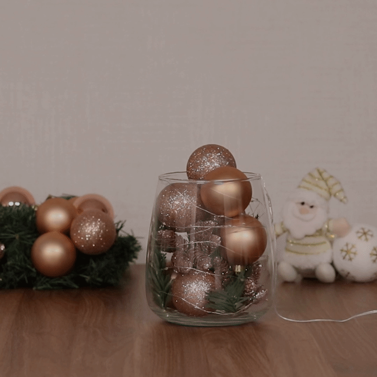 Pote de vidro com bolas de Natal e pisca-pisca.