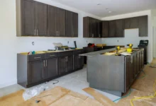 Reforma de uma cozinha com armários de cores escuras.