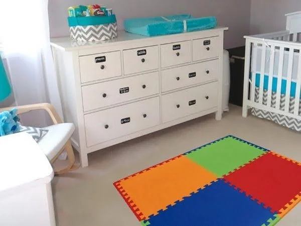 Quarto infantil de cores claras decorado com um tapete de EVA colorido.