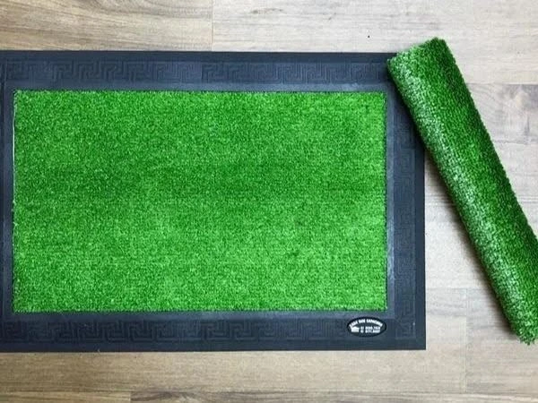 Tapete higiênico com grama sintética verde.